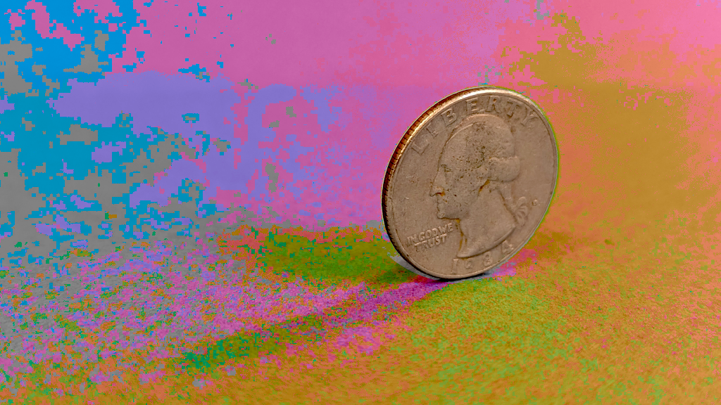 A quarter coin is balancing on its edge on a colorful background