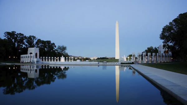 Landscape picture featuring the Washington Monument reflected in the pool at sunrise.